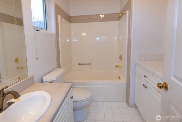 a bathroom with a granite countertop toilet a sink and bathtub