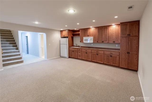 a large kitchen with stainless steel appliances granite countertop a large stove top oven a refrigerator with wooden cabinets