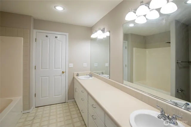 a spacious bathroom with a granite countertop sink a mirror and a shower