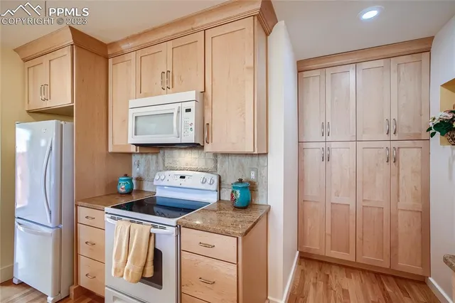 a kitchen with stainless steel appliances granite countertop a refrigerator and a stove top oven
