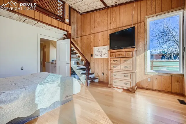 a view of hallway with wooden floor and flat screen tv