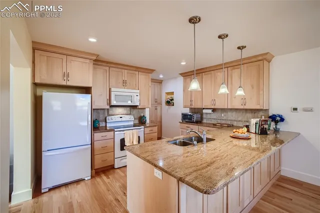 a kitchen with kitchen island a sink a stove a refrigerator and cabinets