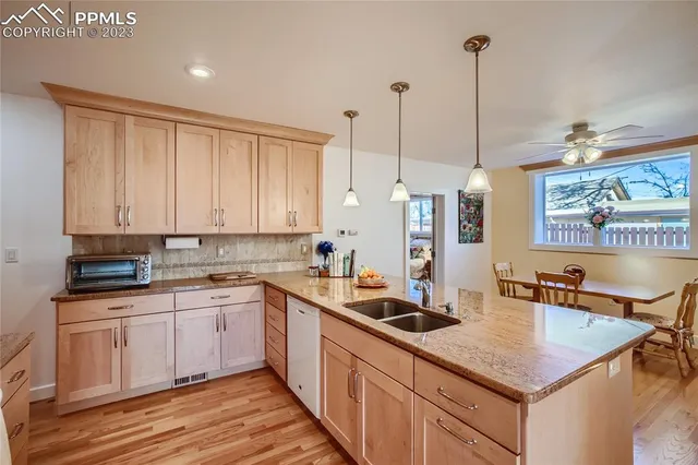 a kitchen with stainless steel appliances granite countertop a sink a stove and a wooden floors