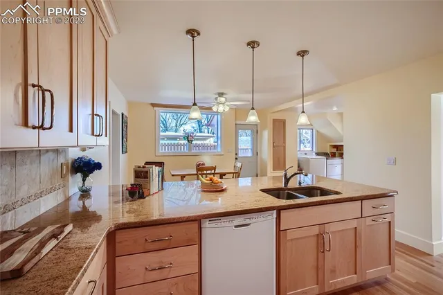 a kitchen with stainless steel appliances granite countertop a sink a stove and a wooden floors
