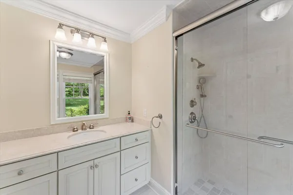 a bathroom with a shower sink and mirror