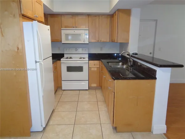 a kitchen with a refrigerator sink stove and cabinets