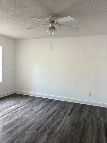 a view of a room with wooden floor and a ceiling fan
