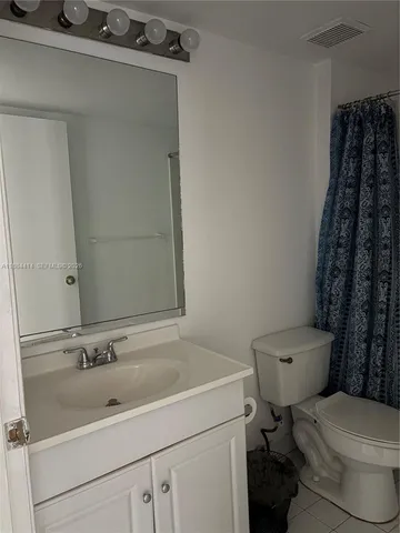 a bathroom with a sink toilet and a mirror