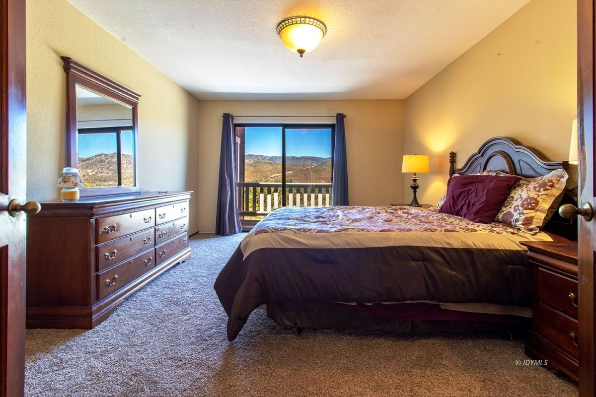 59382 Hop Patch Spring Road Mountain Center, CA 92561 - Photo 32 of 47 a spacious bedroom with a bed and a dresser next to a window
