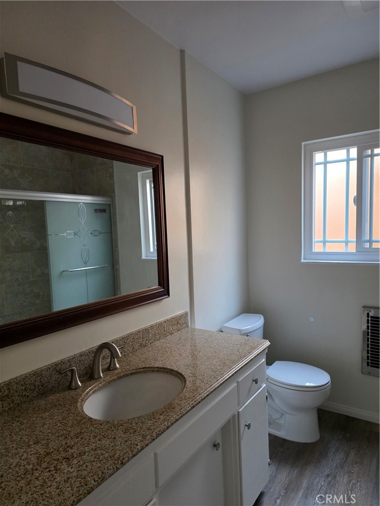 3136 Perlita Avenue, Unit 1 Atwater Village, CA 90039 - Photo 9 of 10 a bathroom with a granite countertop toilet sink and mirror