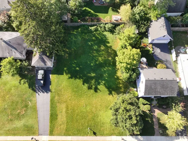 an aerial view of a house with swimming pool and large trees