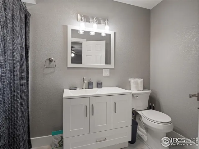 a bathroom with a toilet a sink a vanity and mirror