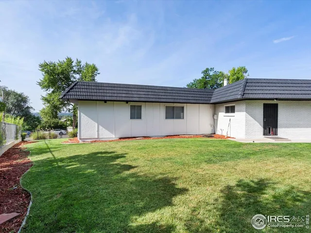 a backyard of a house with plants and barbeque oven