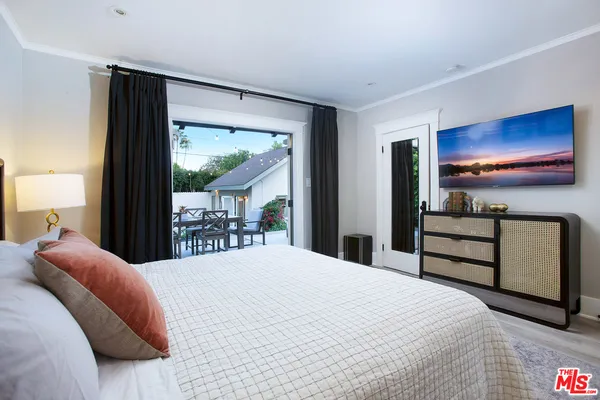 a bedroom with a bed and a flat screen tv