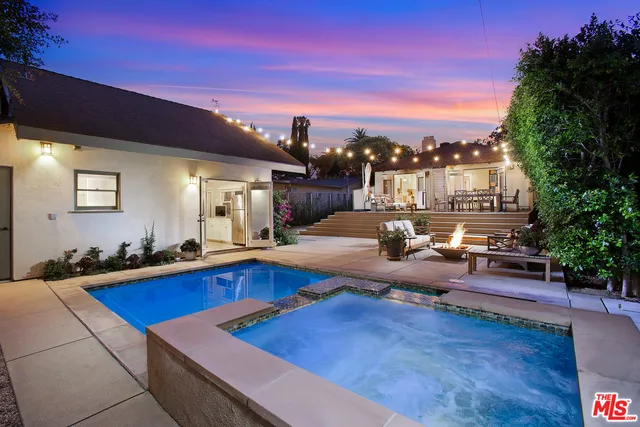 a living room with furniture pool table and kitchen view