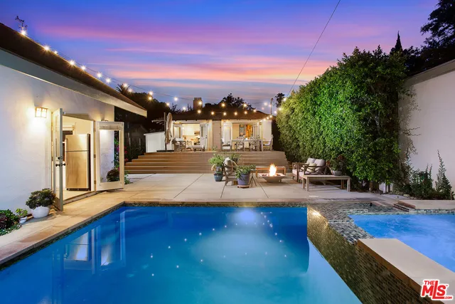 a swimming pool with outdoor seating and yard in the back