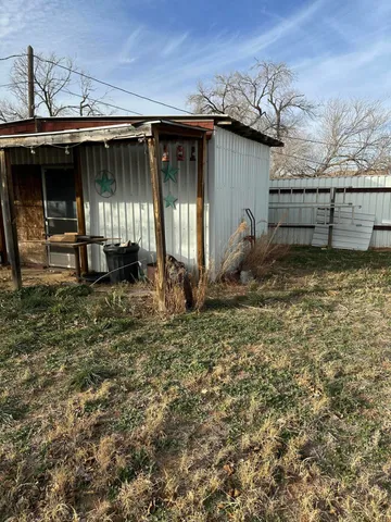 a backyard of a house with barbeque oven table and chairs
