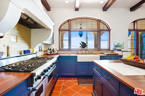 a kitchen with a stove a sink and a wooden cabinets