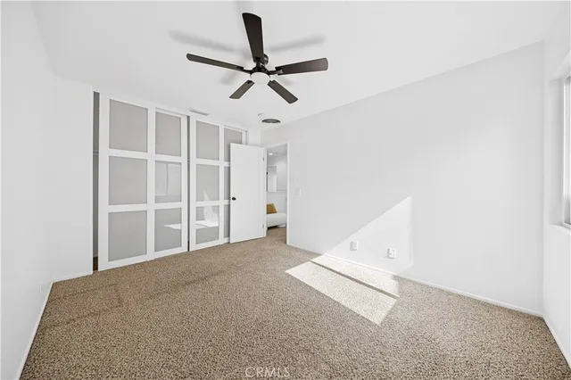 a view of a livingroom with a ceiling fan and window