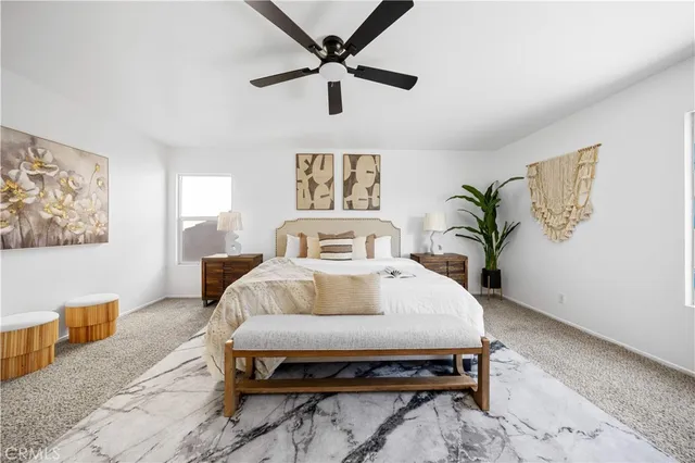 a spacious bedroom with a bed and a potted plant on the dresser