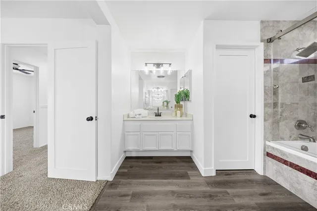 a bathroom with a tub shower sink and mirror