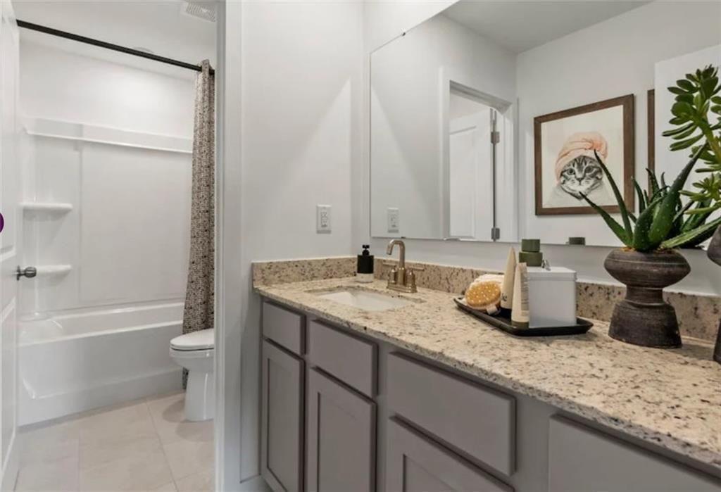 114 Poplar Blf Way Jefferson, GA 30549 - Photo 29 of 32 a bathroom with a granite countertop sink a toilet and a bathtub