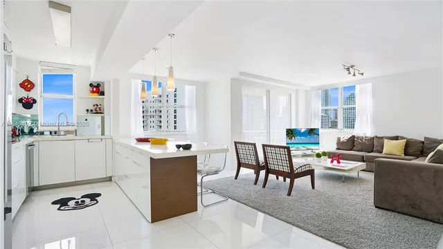 a living room with furniture and a dining table with kitchen view