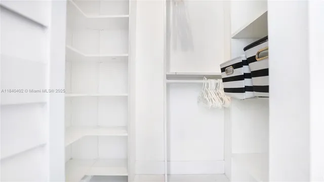 a view of walk in closet with empty racks