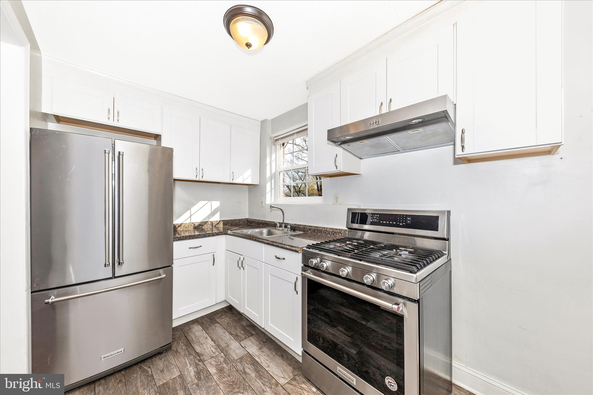 8109 Riggs Road Hyattsville, MD 20783 - Photo 11 of 54 a kitchen with stainless steel appliances granite countertop a stove a refrigerator and a microwave