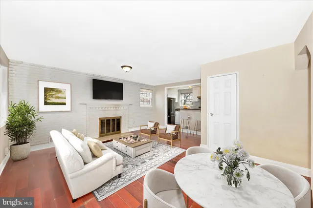 a living room with furniture a fireplace and a potted plant