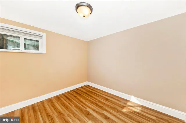 a view of a room with wooden floor and a ceiling fan