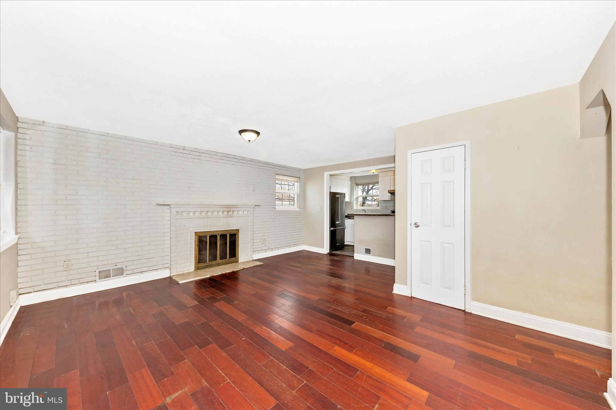 8109 Riggs Road Hyattsville, MD 20783 - Photo 6 of 54 a view of a livingroom with wooden floor and a fireplace