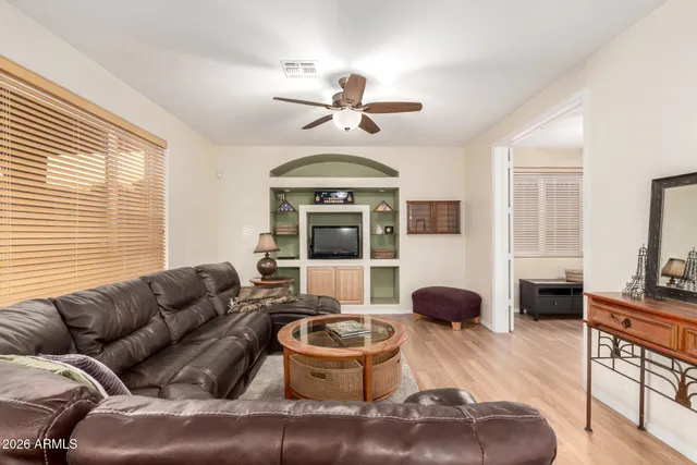 a living room with furniture ceiling fan and a window