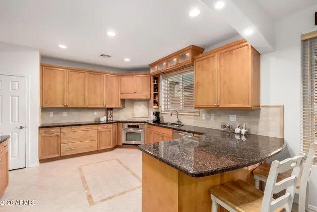 a kitchen with stainless steel appliances granite countertop a sink a stove and cabinets