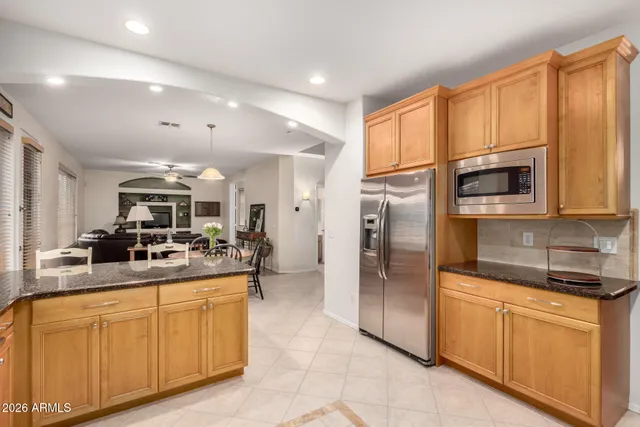 a kitchen with stainless steel appliances granite countertop a refrigerator a stove and a sink with cabinets