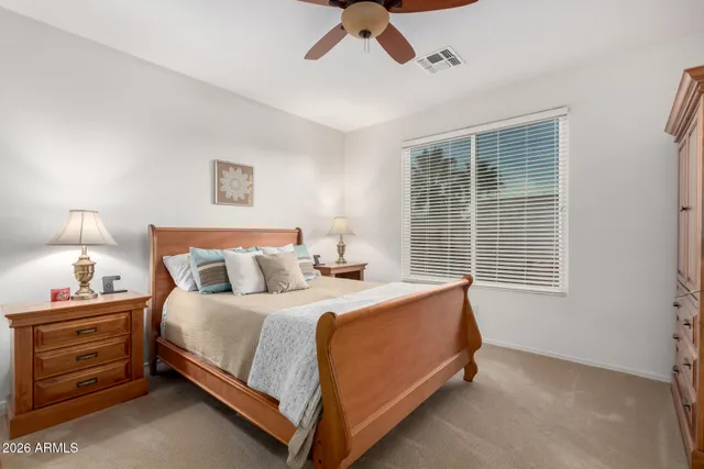 a bedroom with a bed and a ceiling fan