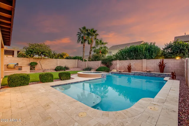 a view of a swimming pool with a lounge chair and a small yard