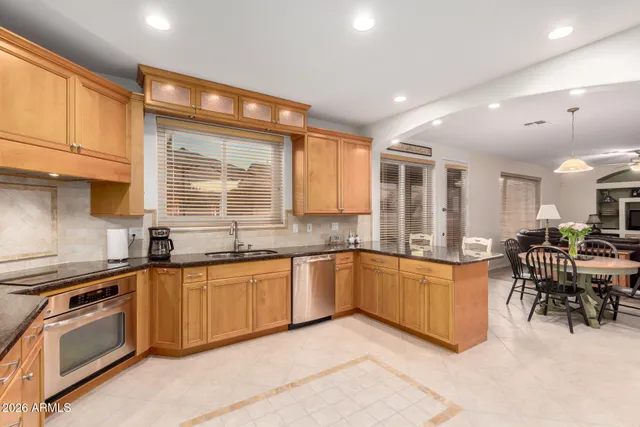 a large kitchen with granite countertop lots of counter top space and stainless steel appliances