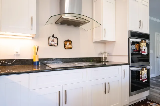 a kitchen with stainless steel appliances a sink a stove a refrigerator cabinets and a dining table