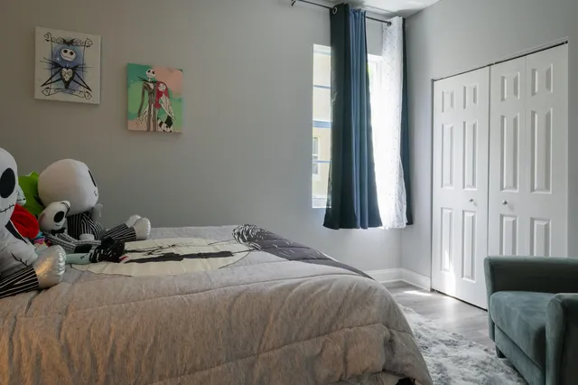 a living room with furniture kitchen view and a wooden floor