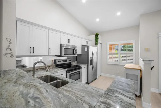 a view of a kitchen with a refrigerator and a window