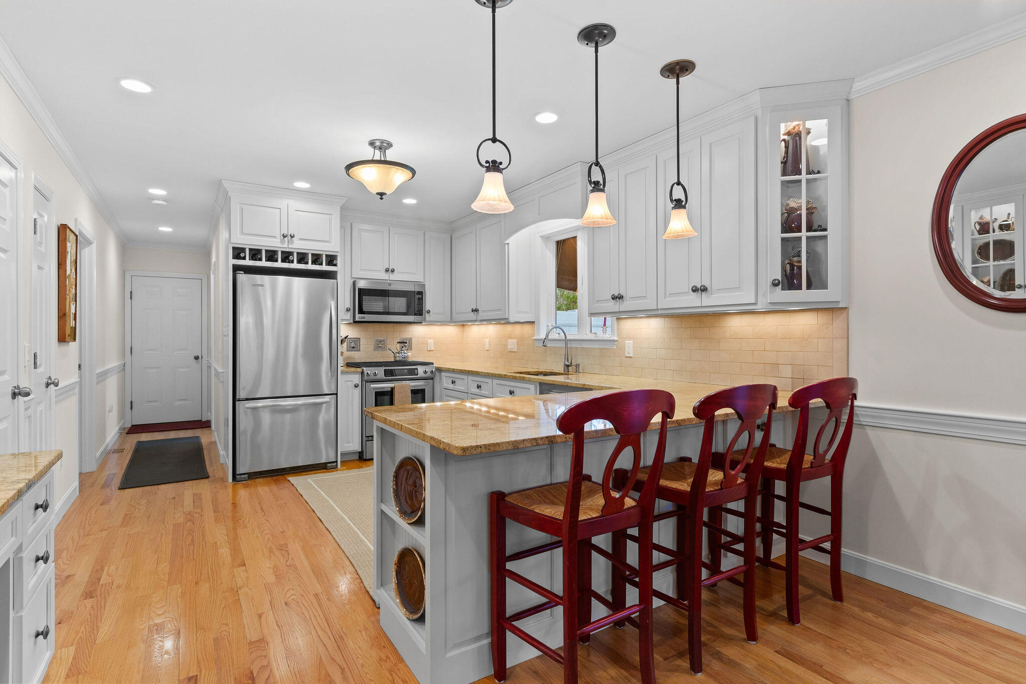 154 Beechtree Drive Brewster, MA 02631 - Photo 37 of 76 a kitchen with stainless steel appliances a dining table chairs sink and cabinets