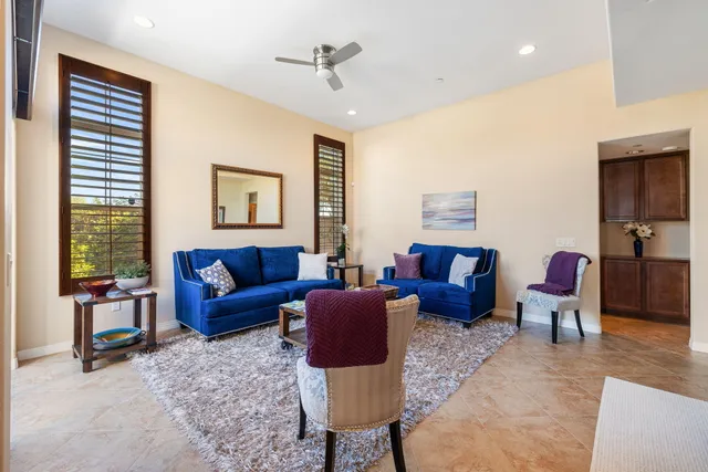 a living room with furniture ceiling fan and a window