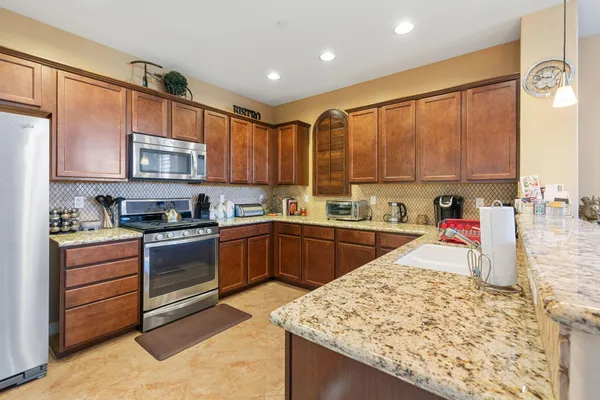 a kitchen with stainless steel appliances granite countertop a stove sink and cabinets