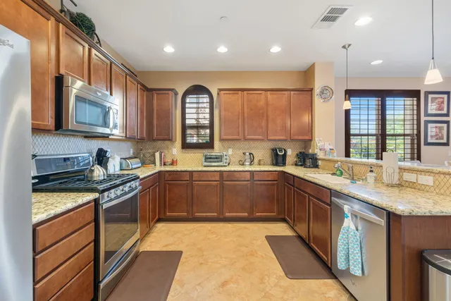 a kitchen with stainless steel appliances granite countertop a stove sink and cabinets