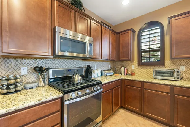 a kitchen with stainless steel appliances granite countertop a sink stove and cabinets
