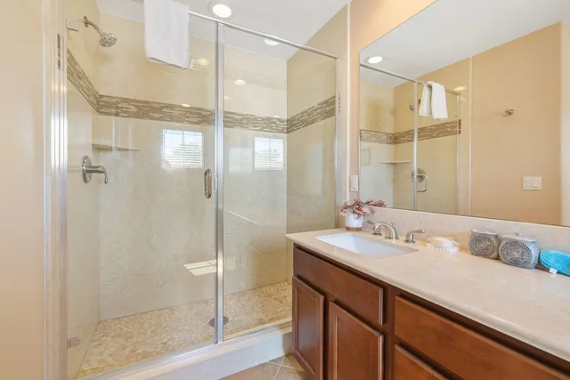 a bathroom with a shower sink and mirror