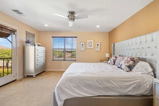 a spacious bedroom with a bed a dresser and a window
