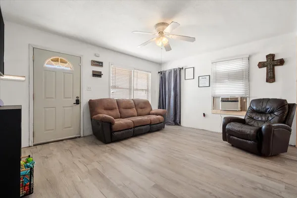 a living room with furniture and ceiling fan