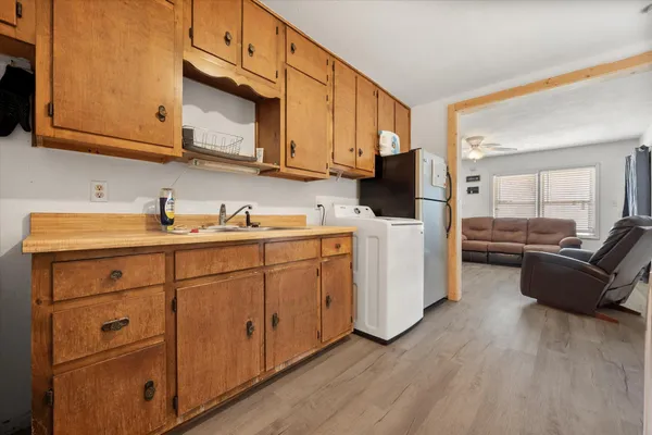 a kitchen with stainless steel appliances granite countertop a refrigerator a stove a sink dishwasher and white cabinets with wooden floor